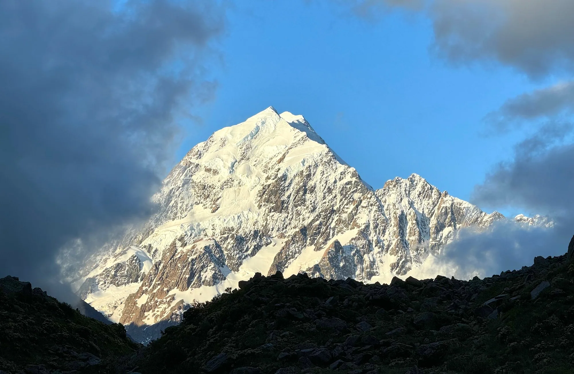 Aoraki framed by dark clouds on the walk to Kea Point