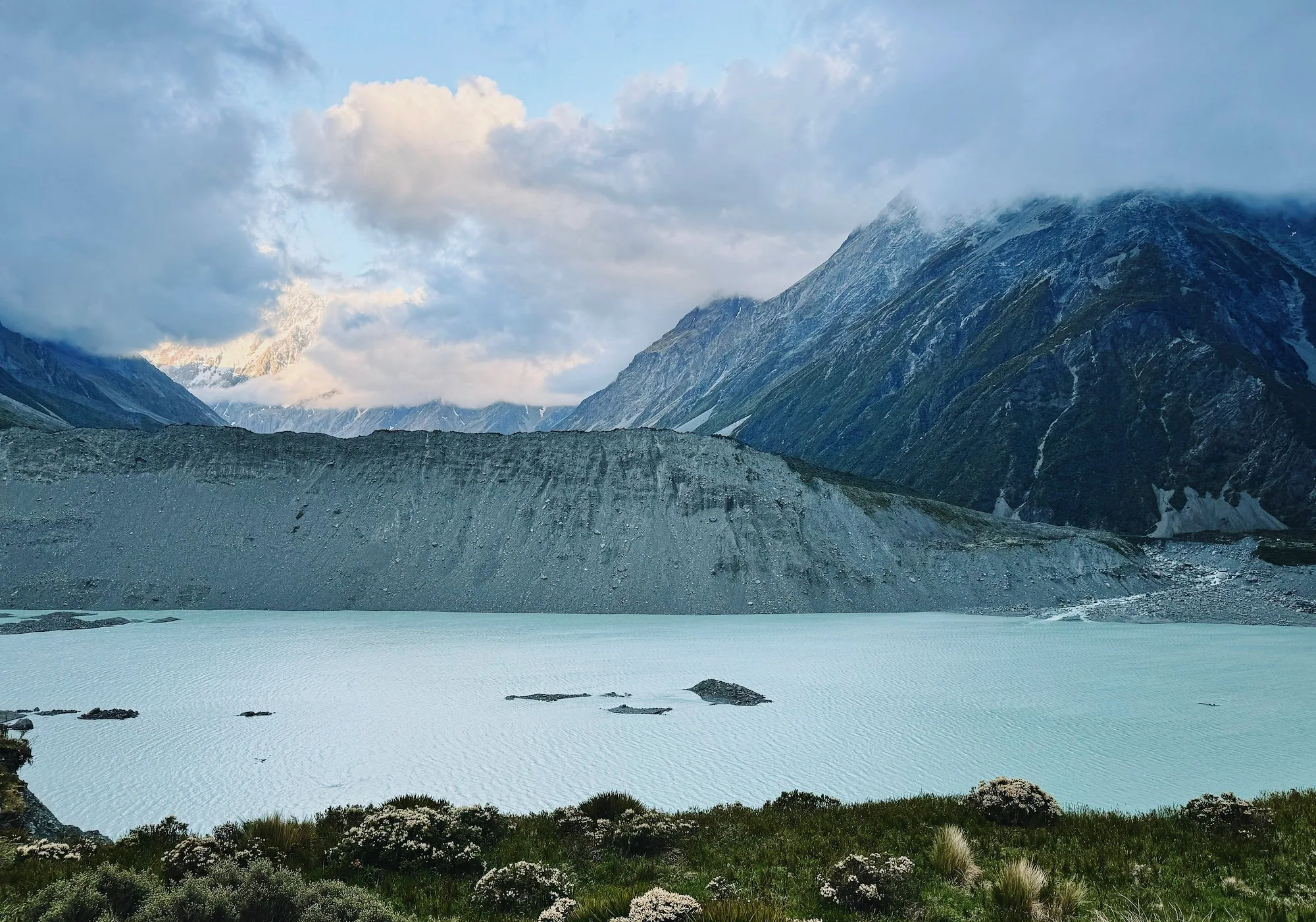 Mueller Lake and its moraine beneath cloud-covered mountains at Kea Point