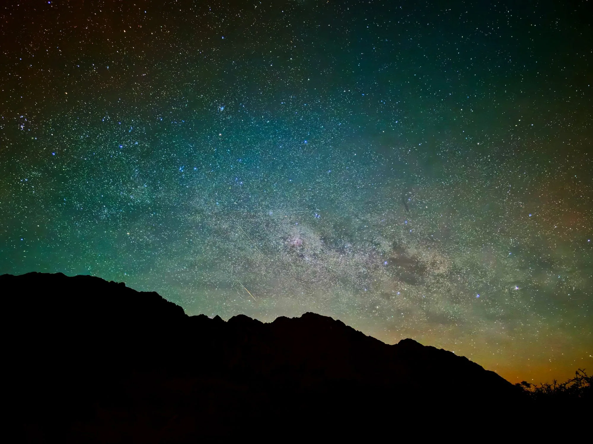 The Milky Way glowing above a dark mountain ridge in Aoraki / Mount Cook National Park