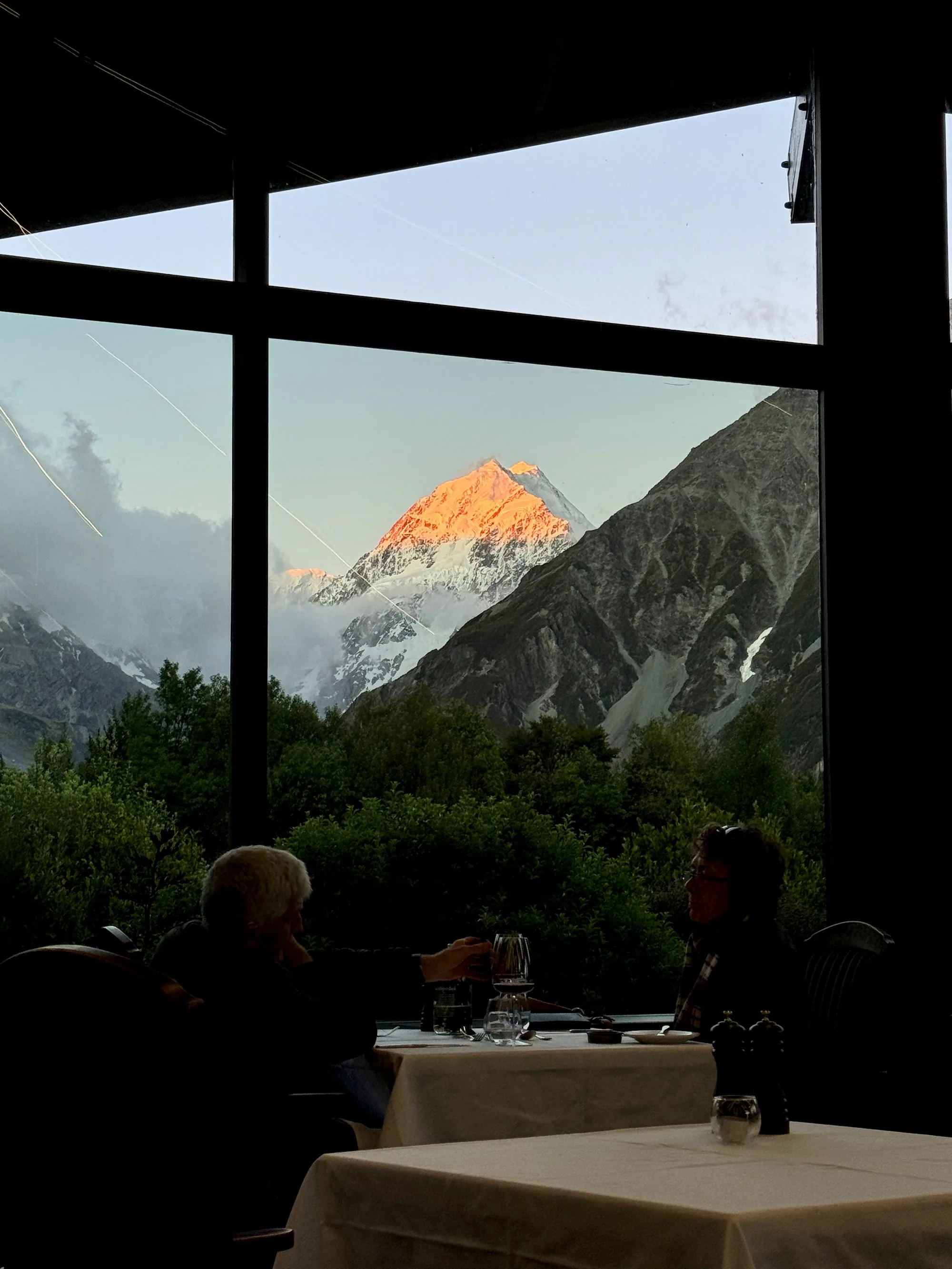 Aoraki glowing orange at sunset beyond the Hermitage dining room