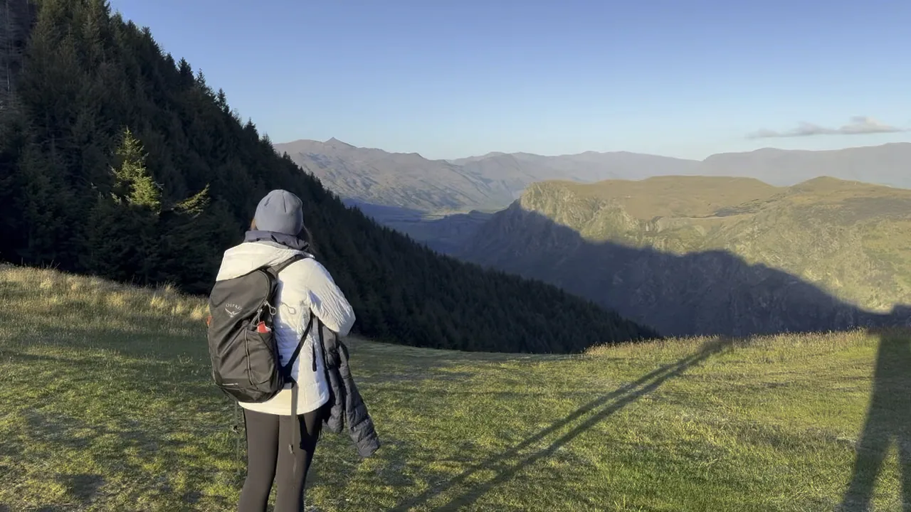 A hiker overlooking layered hills from the Skyline Loop Track