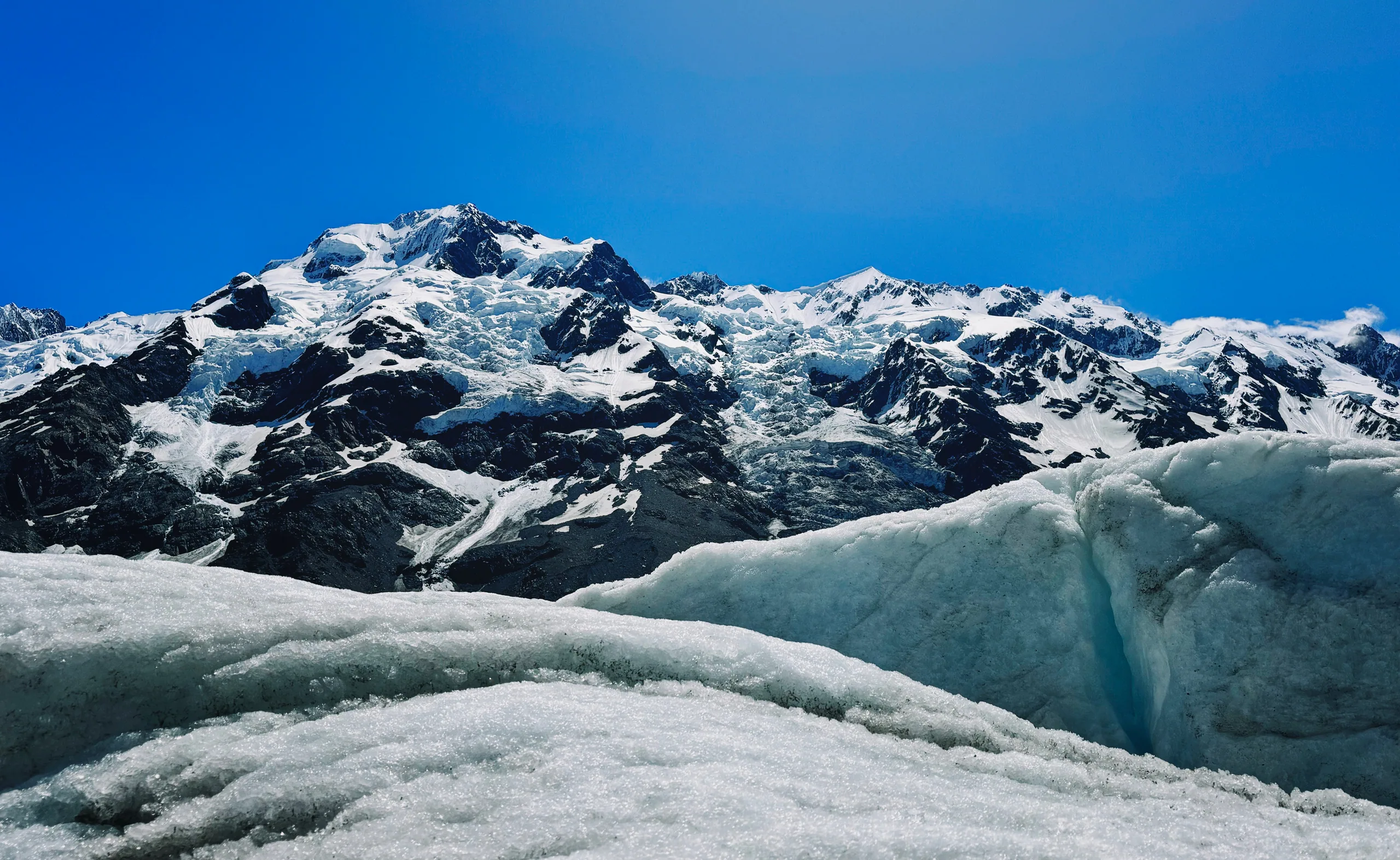 Blue glacier ice beneath the snowy Minarets on the Tasman Glacier