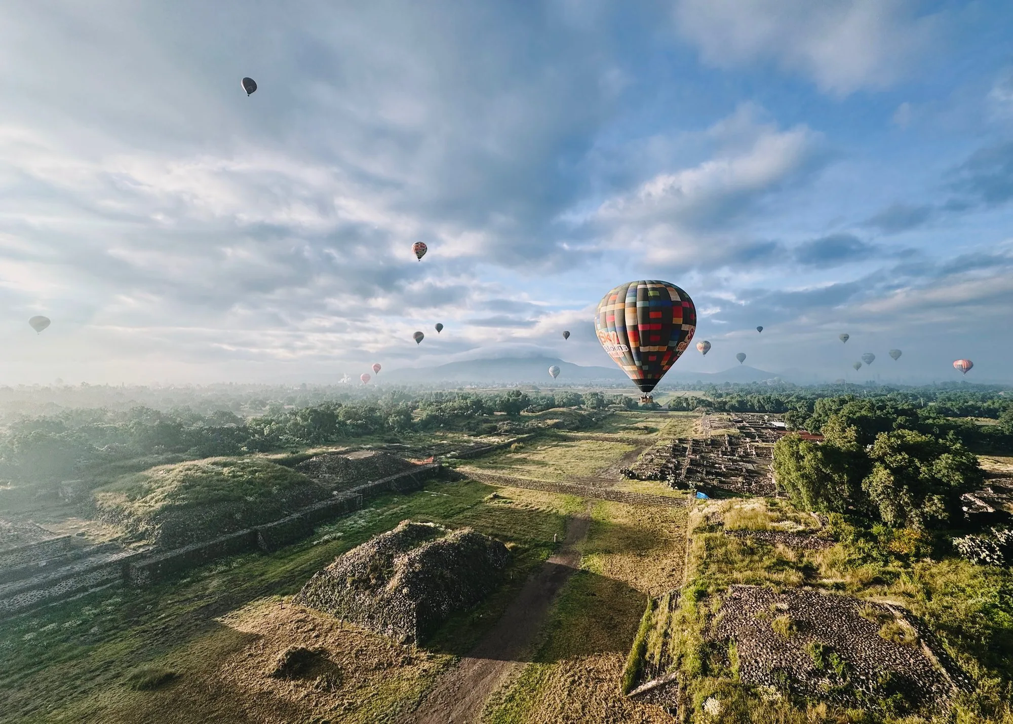 A hot air balloon floating above the Avenue of the Dead