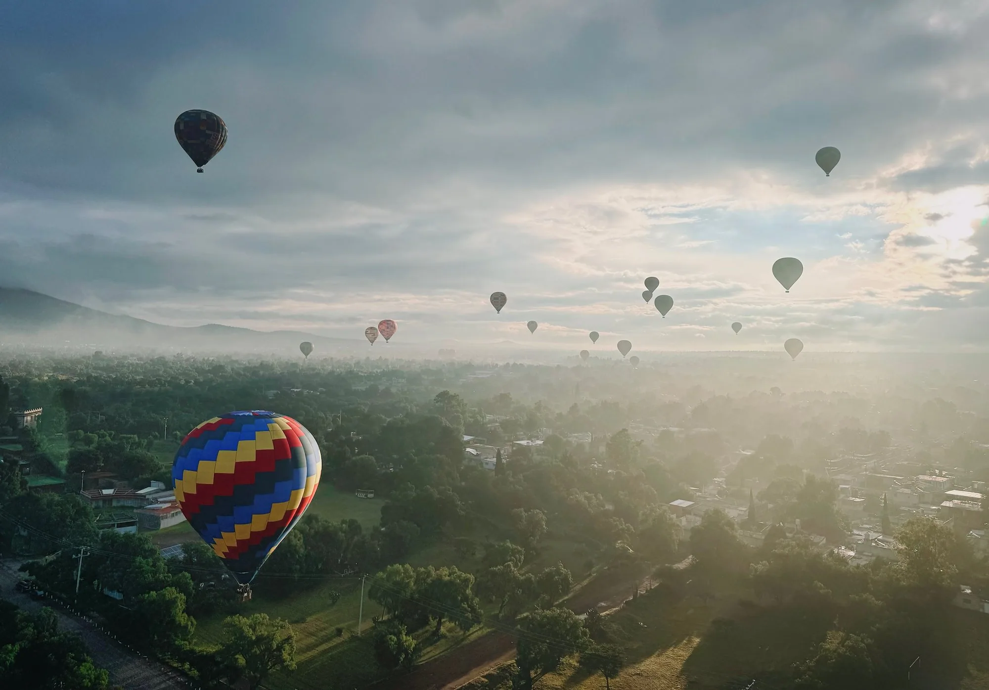 Balloons floating above the ancient city under heavy clouds