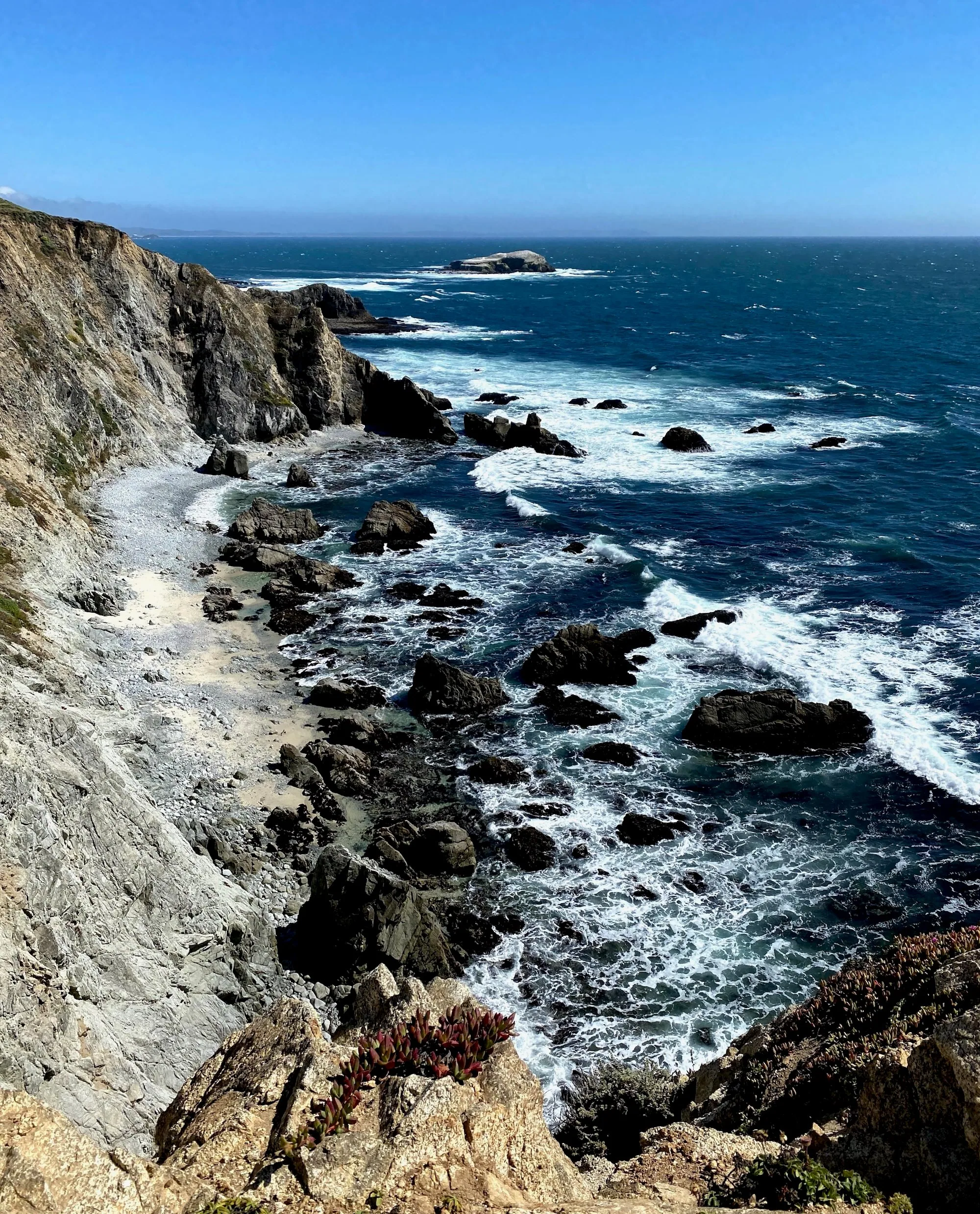 A hiker following the trail above steep coastal cliffs