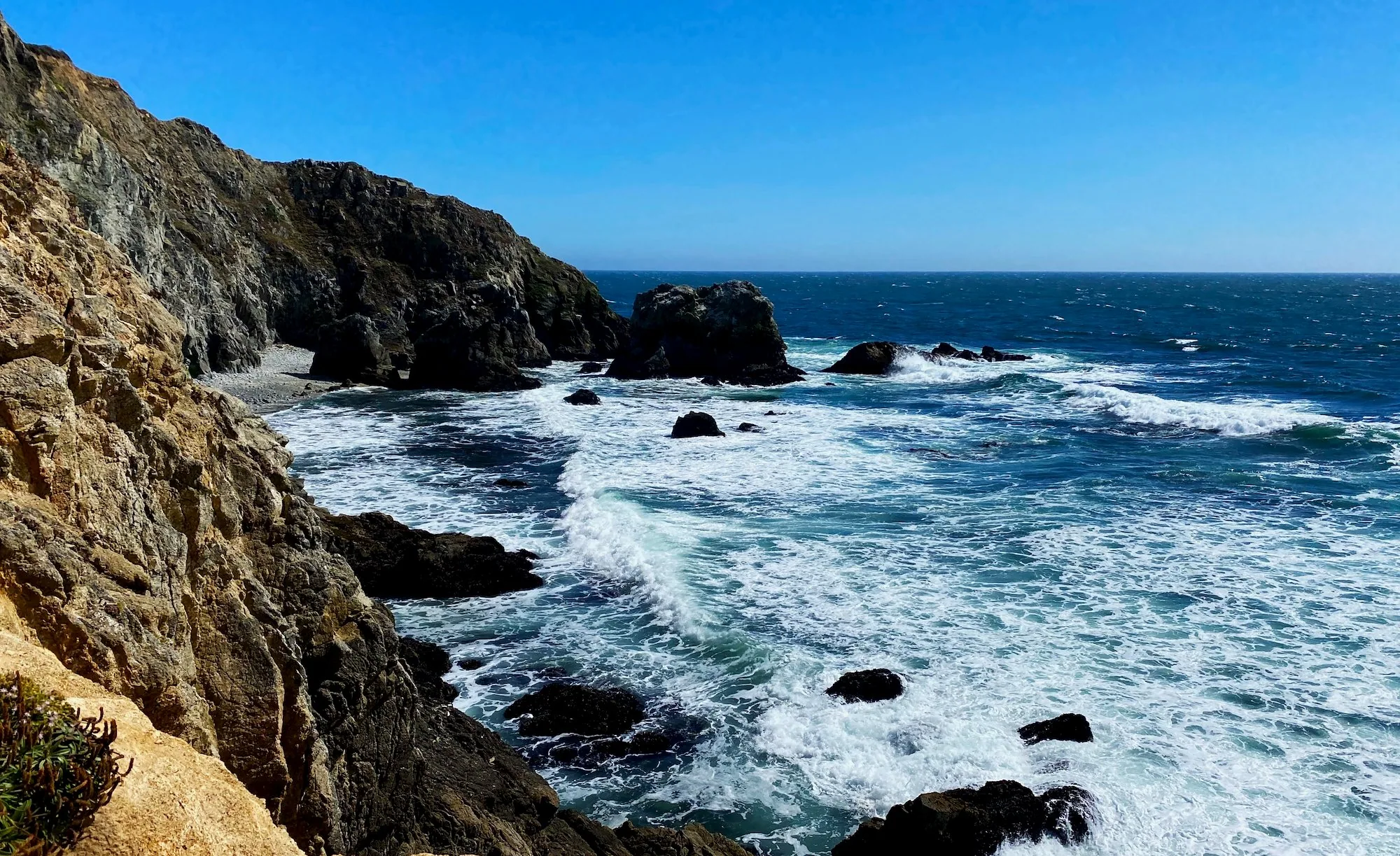 A hiker standing above the breaking waves at the point